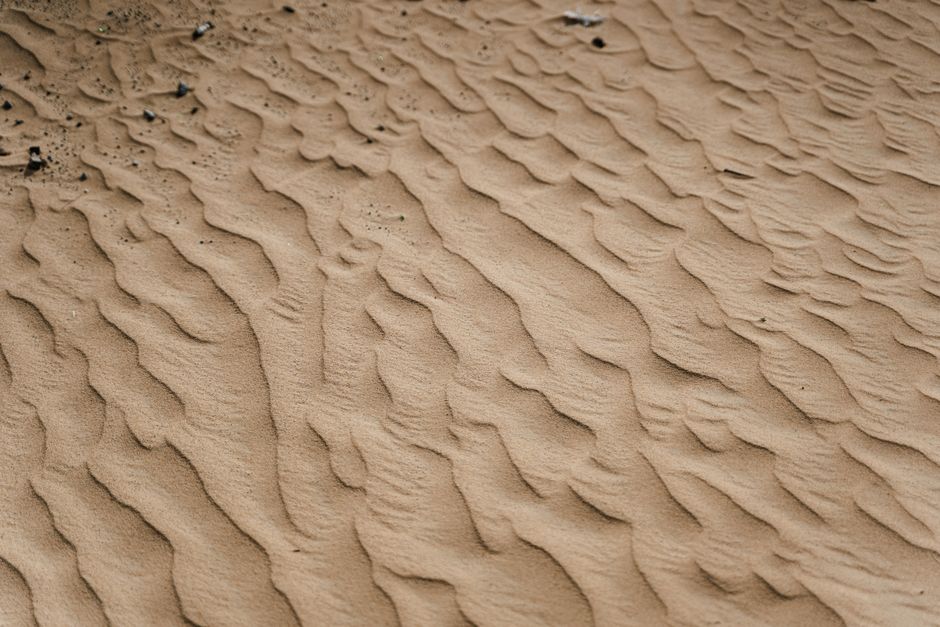 A close-up view of textured sand dunes in a tranquil desert environment.