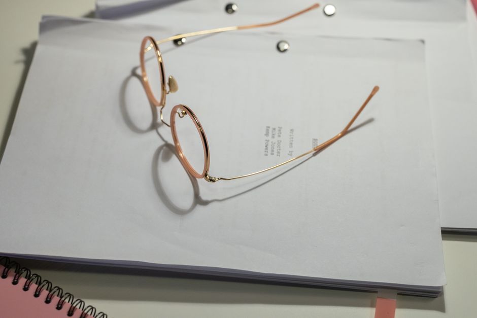 Close-up of eyeglasses resting on a stack of documents, emphasizing simplicity and focus.